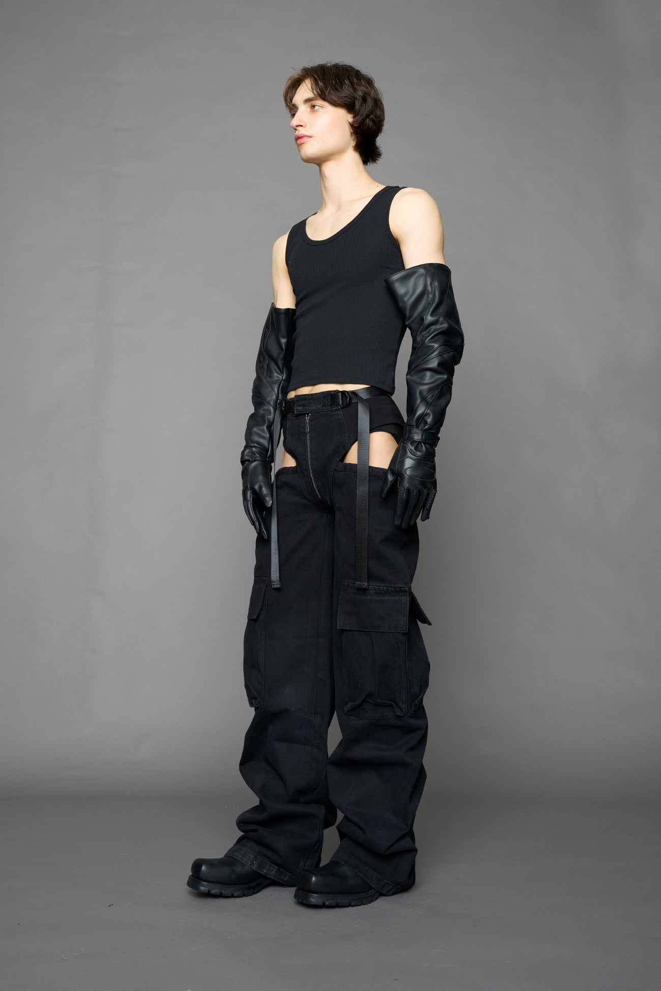 model wearing black dark washed denim trousers with cut out design and 3D pockets