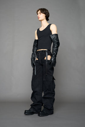 model wearing black dark washed denim trousers with cut out design and 3D pockets