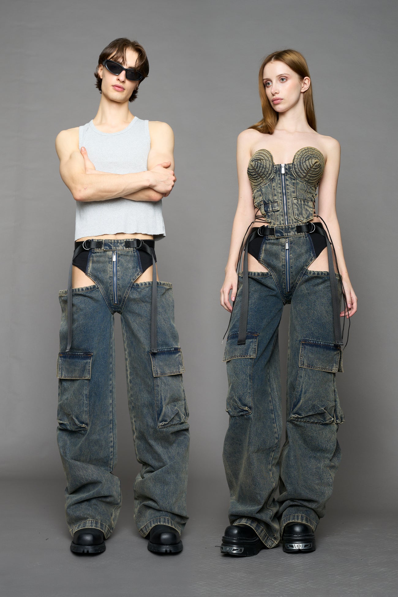 model wearing blue mud washed denim trousers with cut out design and 3D pockets