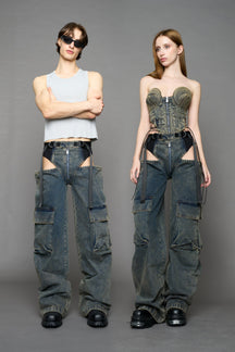 model wearing blue mud washed denim trousers with cut out design and 3D pockets