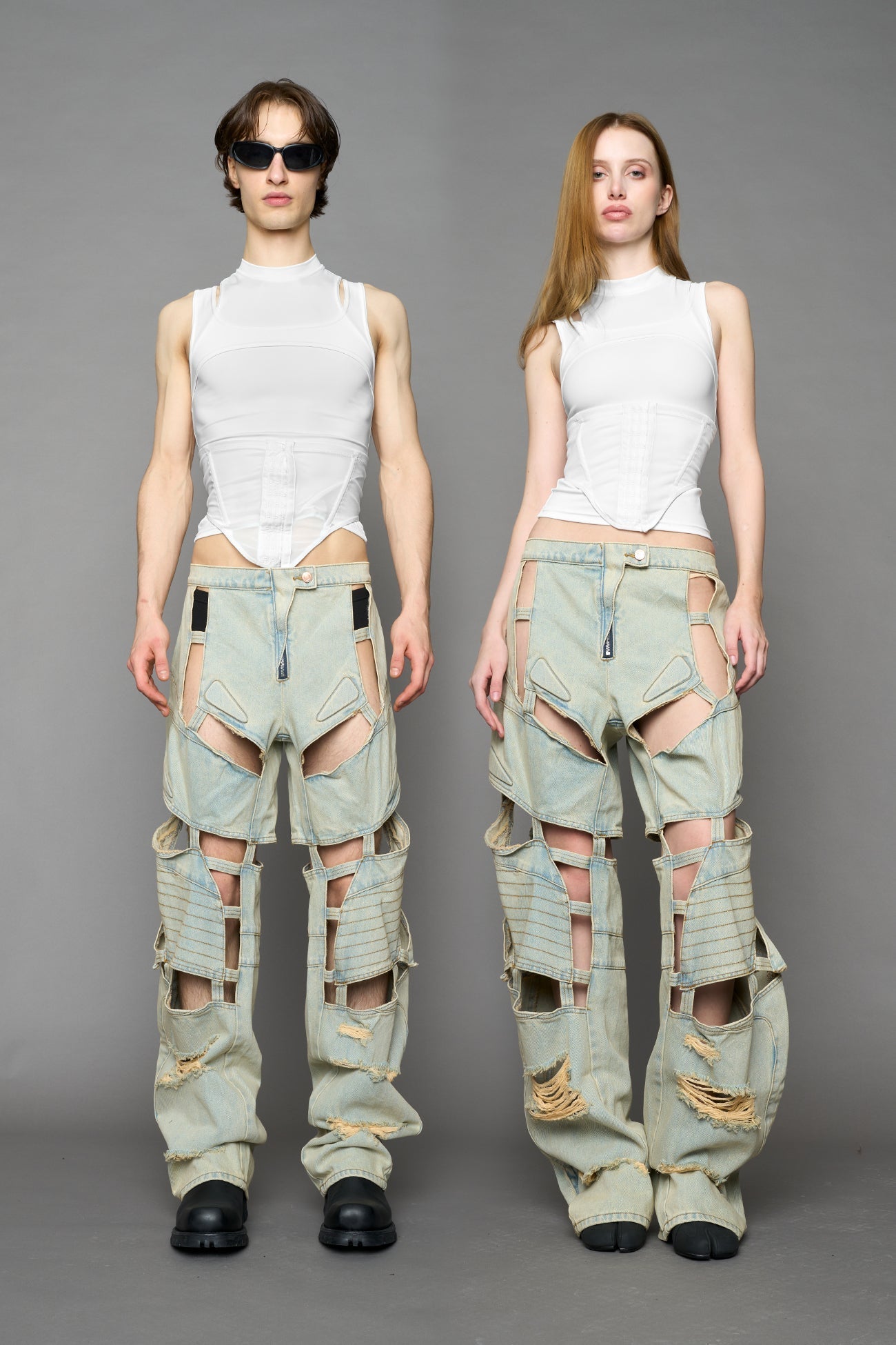 model wearing blue light wash denim pants with motocross inspired cut outs