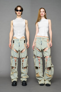 model wearing blue light wash denim pants with motocross inspired cut outs