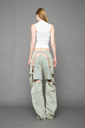 model wearing blue light wash denim pants with motocross inspired cut outs