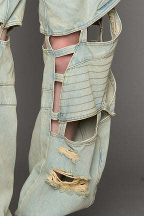 model wearing blue light wash denim pants with motocross inspired cut outs