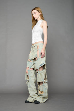 model wearing blue light wash denim pants with motocross inspired cut outs