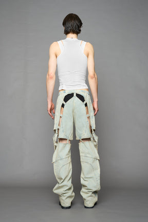 model wearing blue light wash denim pants with motocross inspired cut outs