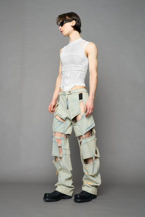 model wearing blue light wash denim pants with motocross inspired cut outs