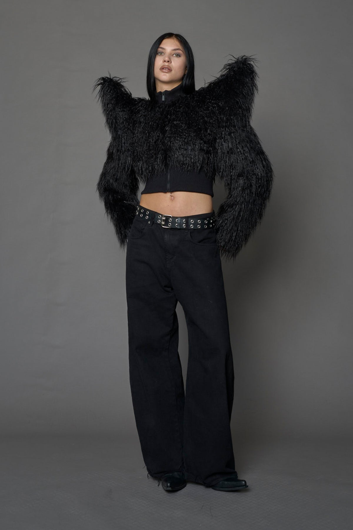 Model wearing black spike shoulder crop faux fur coat