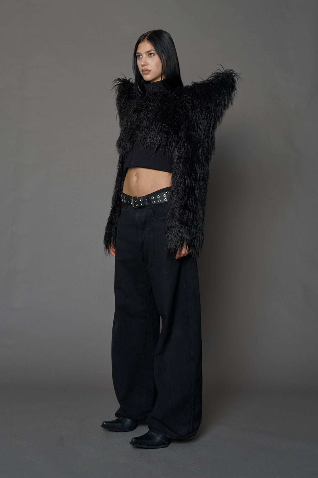 Model wearing black spike shoulder crop faux fur coat