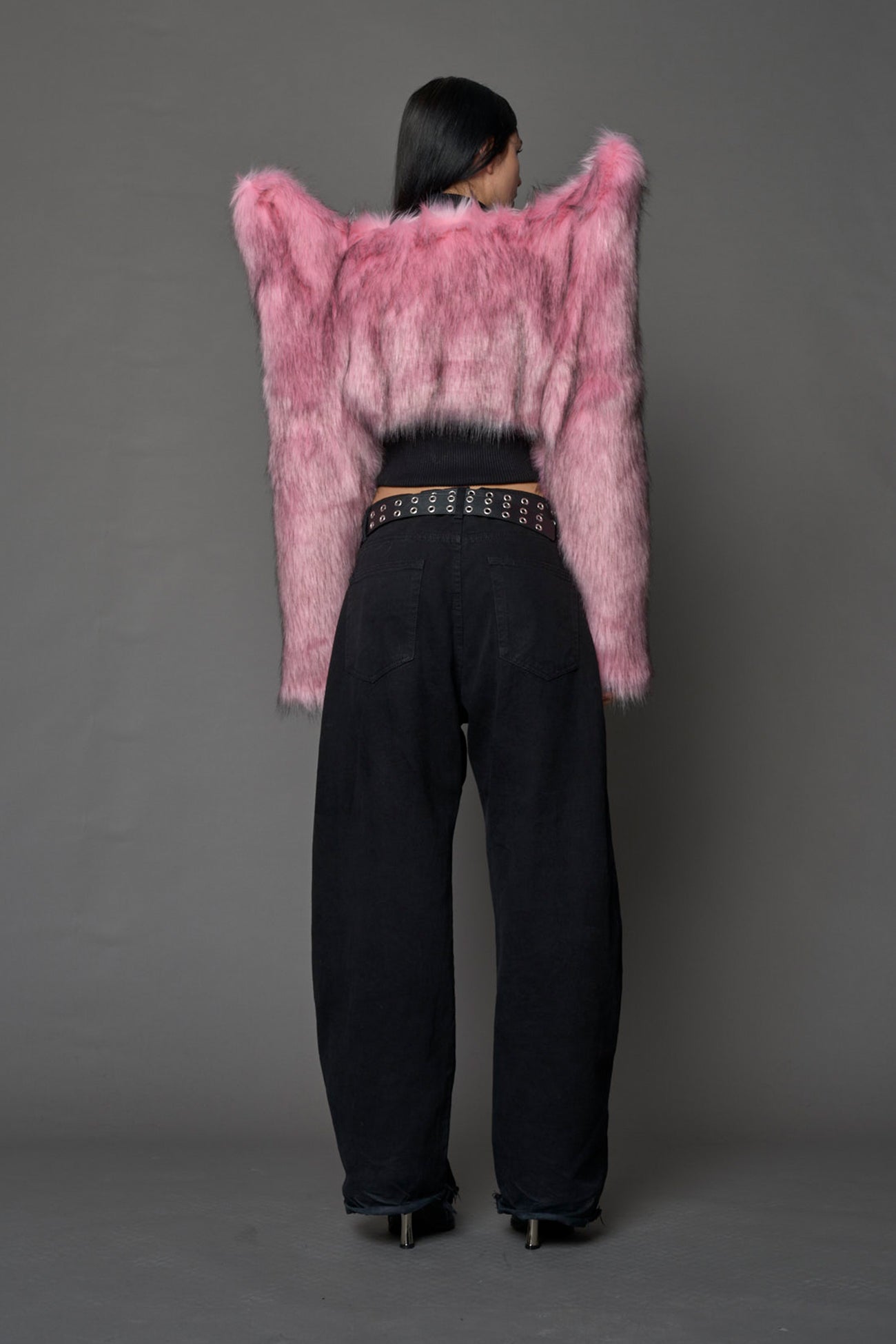 Model wearing pink spike shoulder crop faux fur coat