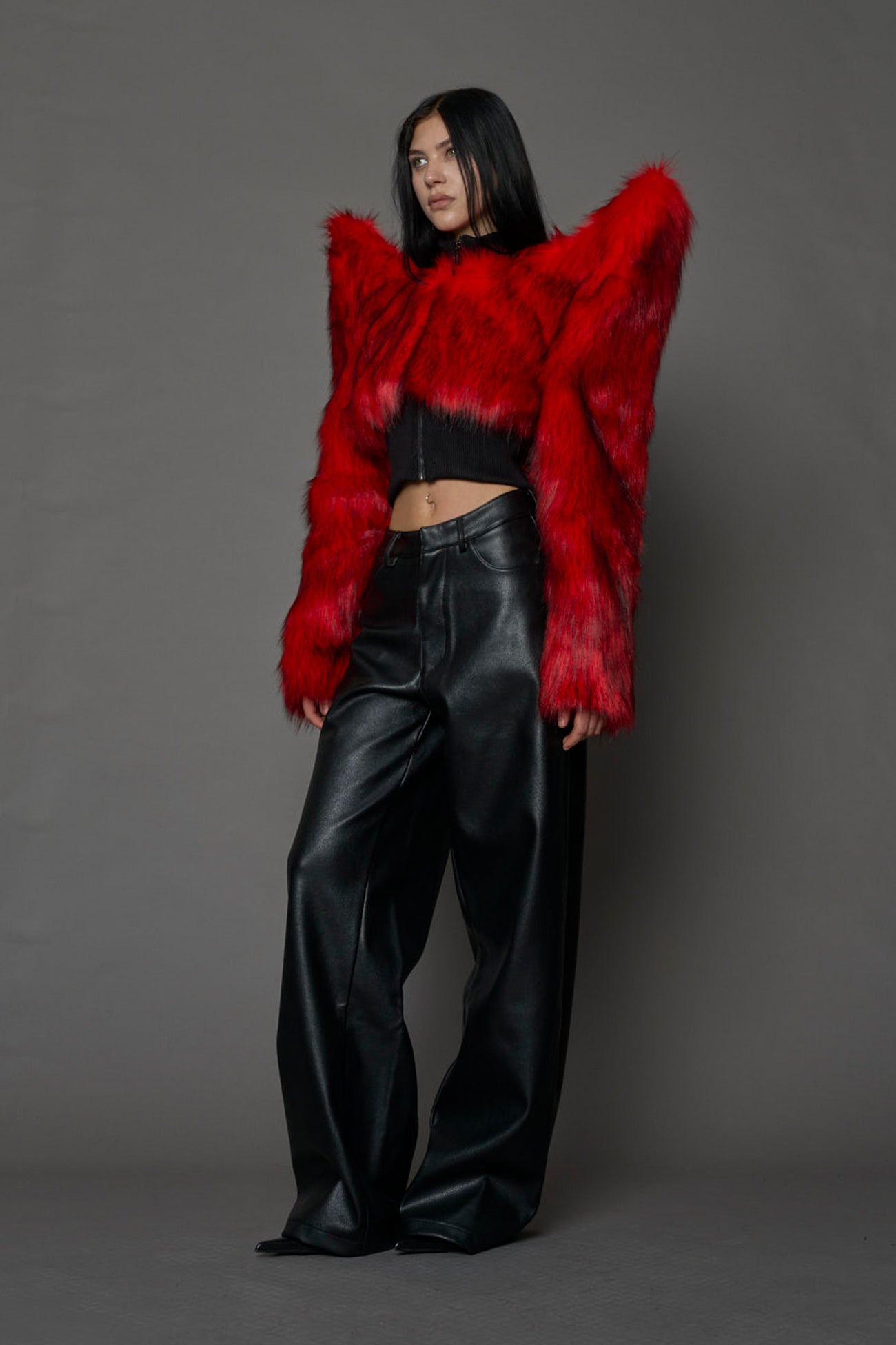 Model wearing red spike shoulder crop faux fur coat