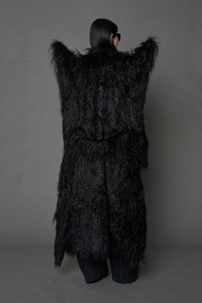 model wearing black spike shoulder long faux fur coat