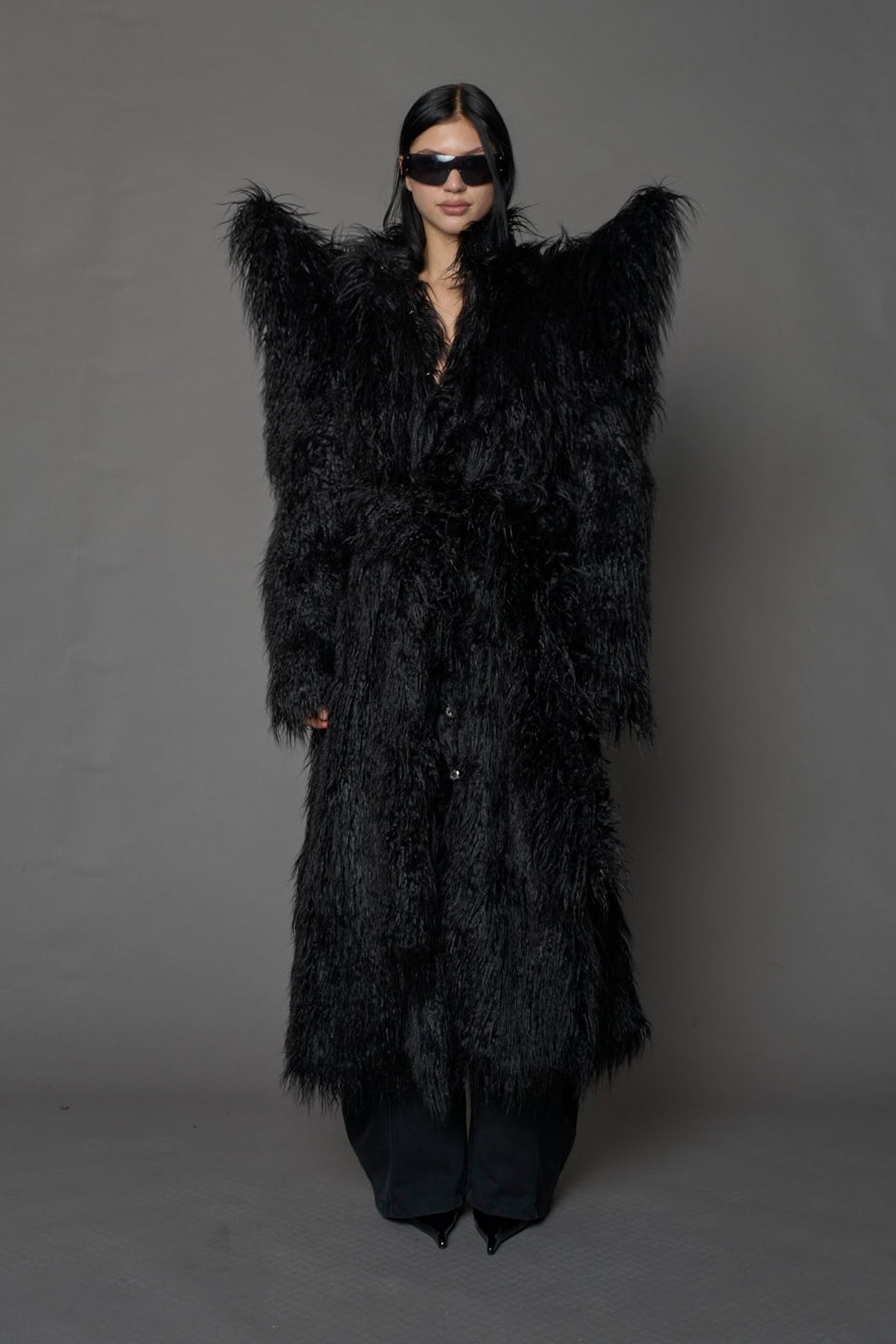 model wearing black spike shoulder long faux fur coat
