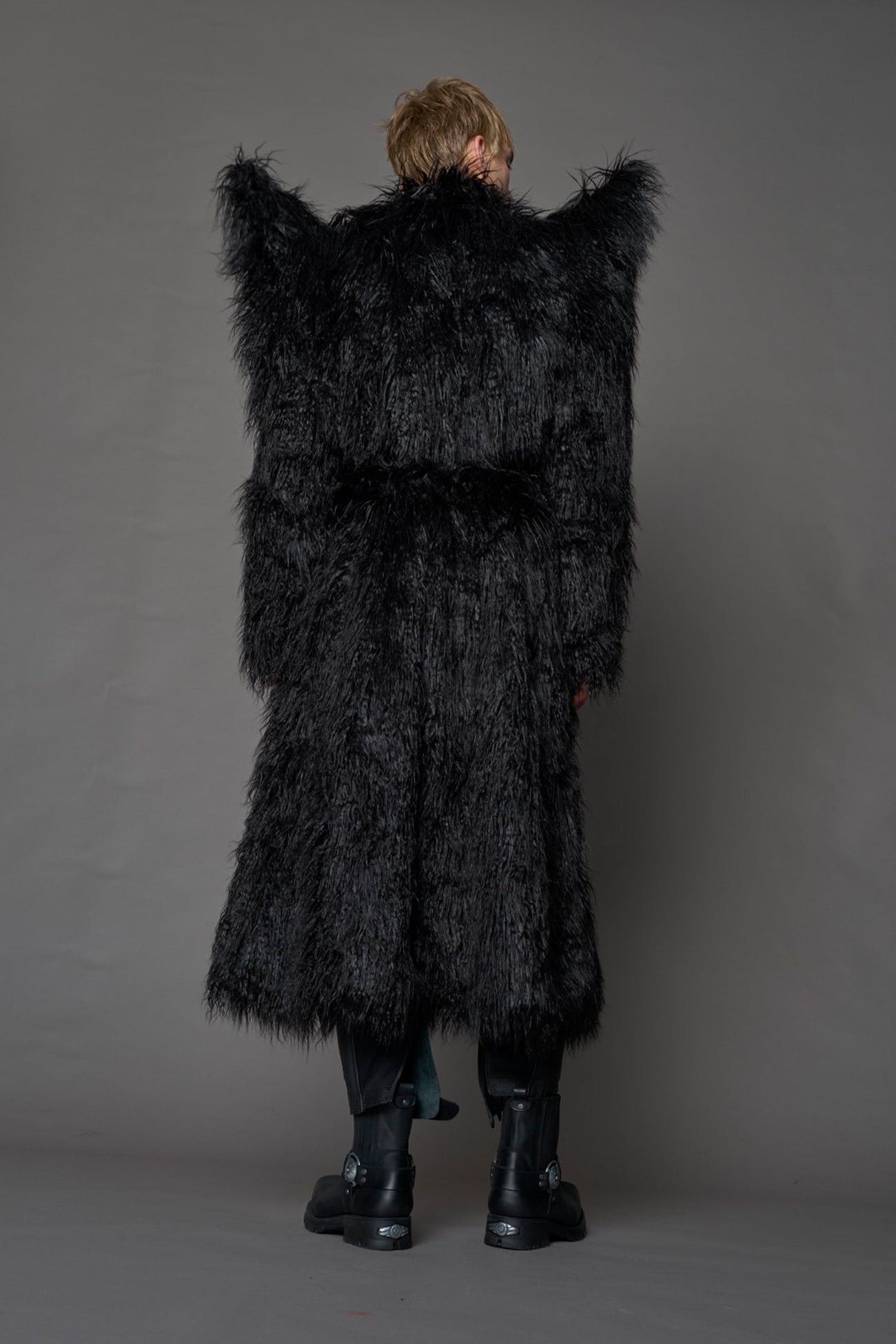 model wearing black spike shoulder long faux fur coat