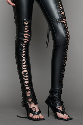 Model wearing Black faux leather lace-up pants with adjustable side lacing