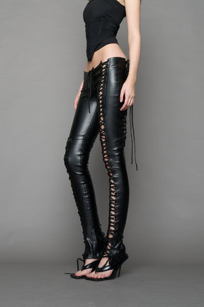 Model wearing Black faux leather lace-up pants with adjustable side lacing