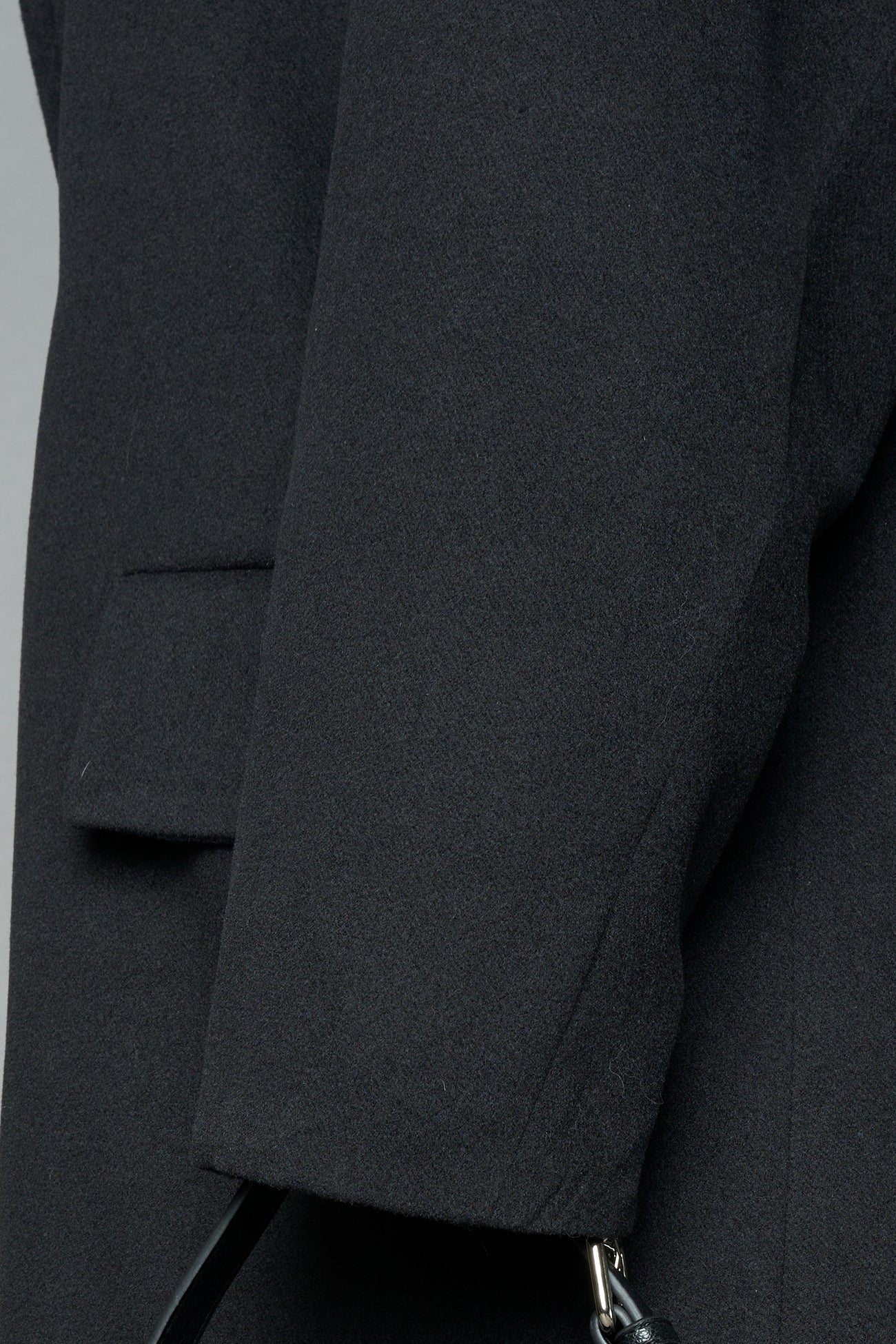 Model wearing long black coat with lapel in wool blend