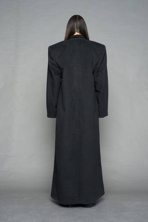 Model wearing long black coat with lapel in wool blend