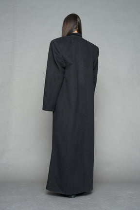 Model wearing long black coat with lapel in wool blend