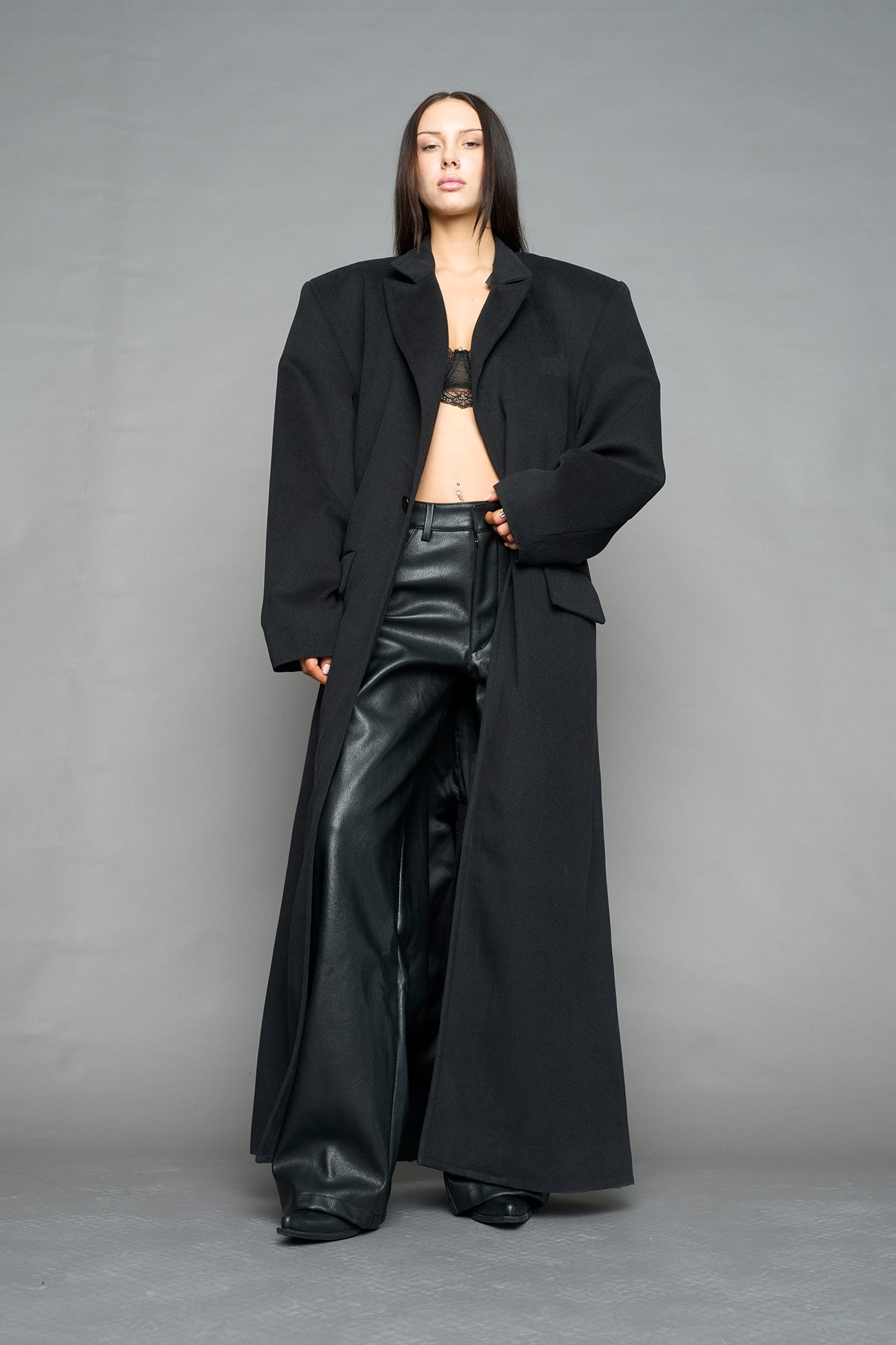 Model wearing long black coat with lapel in wool blend