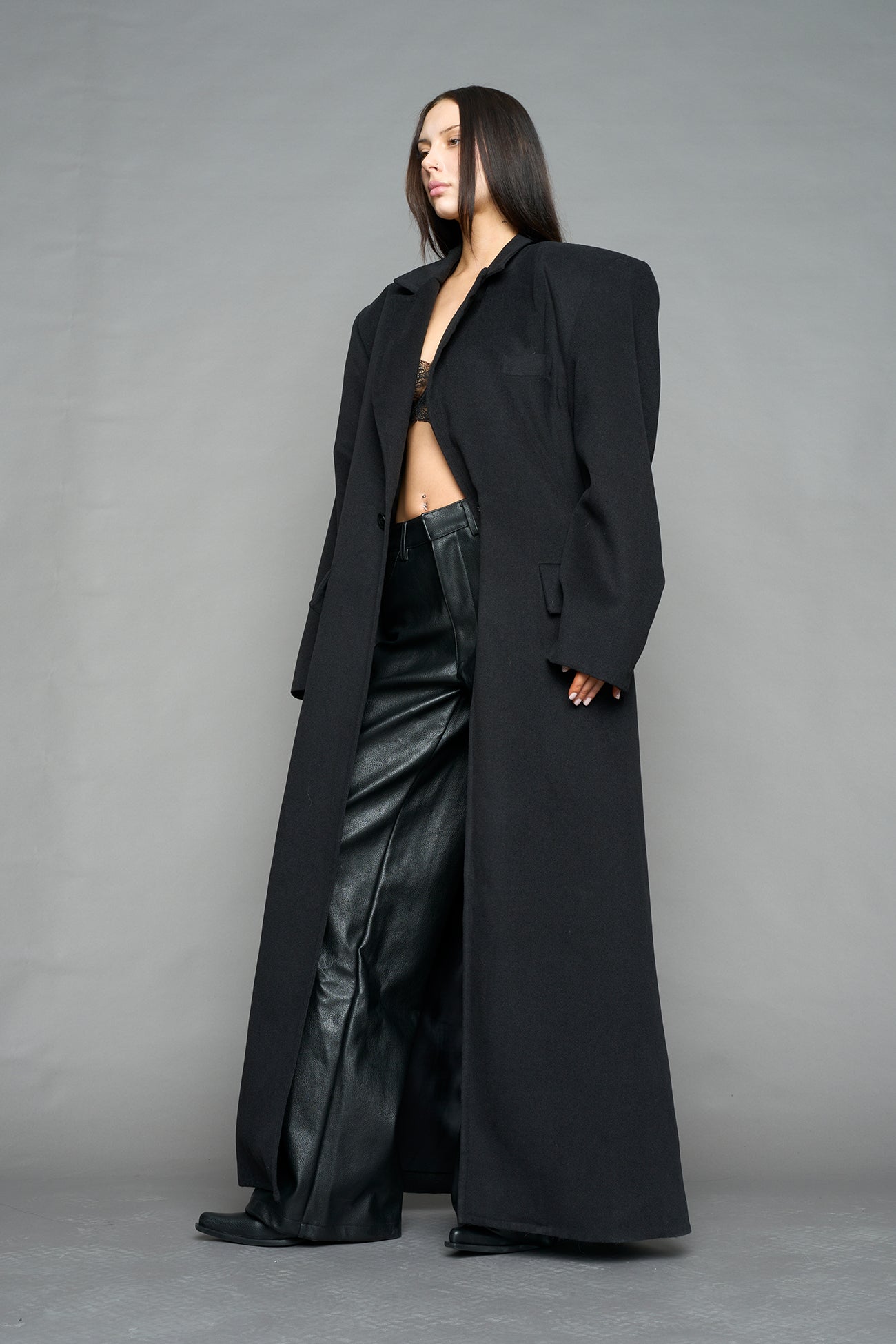 Model wearing long black coat with lapel in wool blend