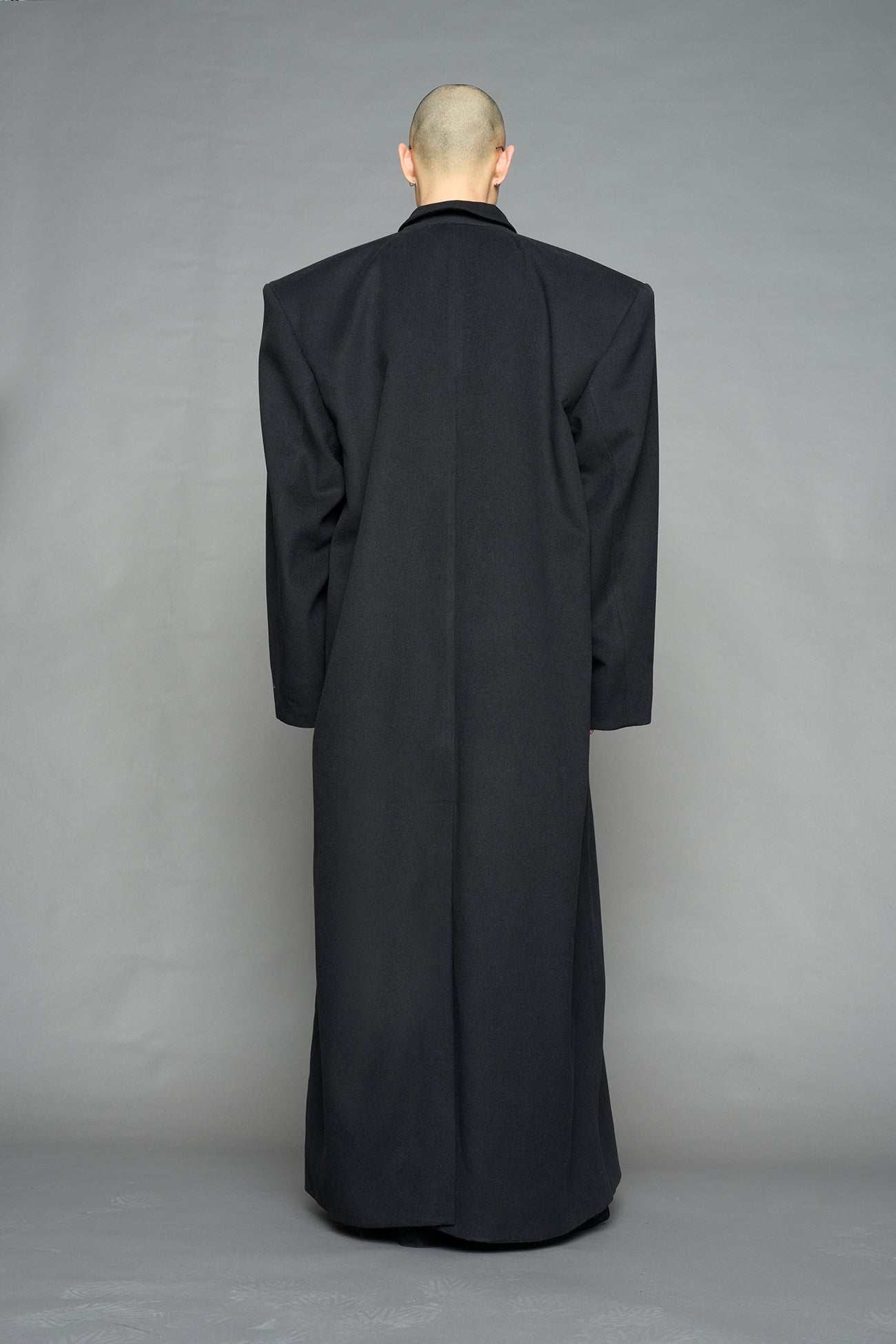 Model wearing long black coat with lapel in wool blend