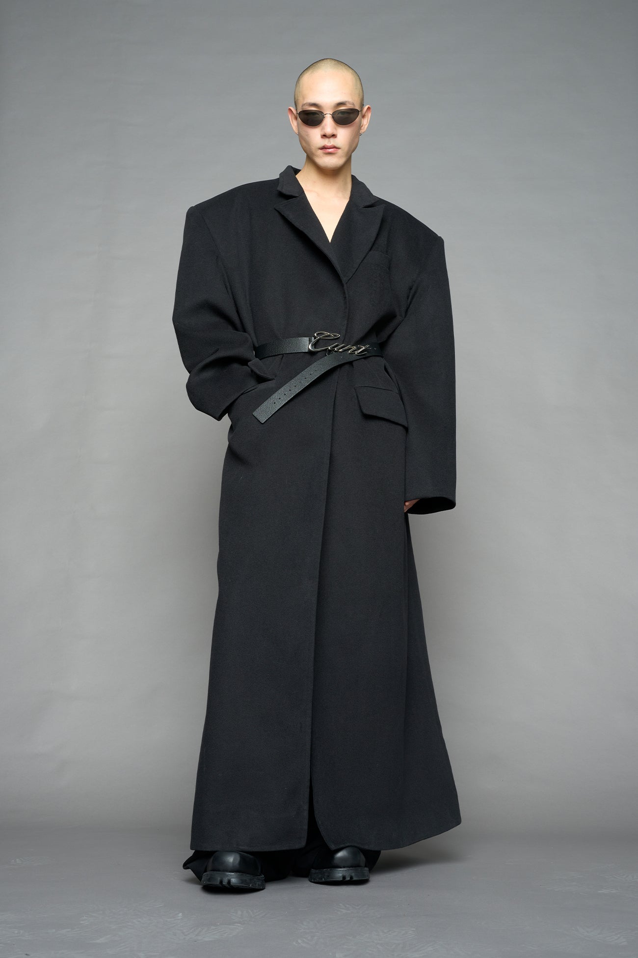 Model wearing long black coat with lapel in wool blend