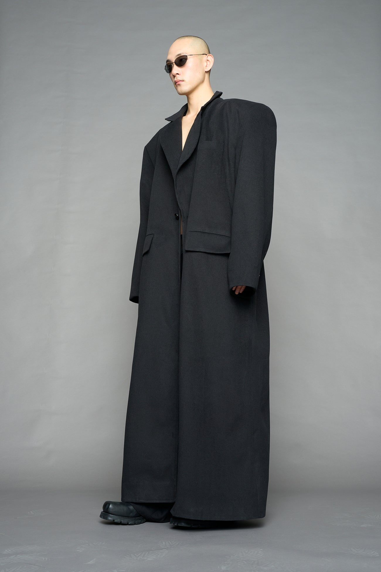 Model wearing long black coat with lapel in wool blend
