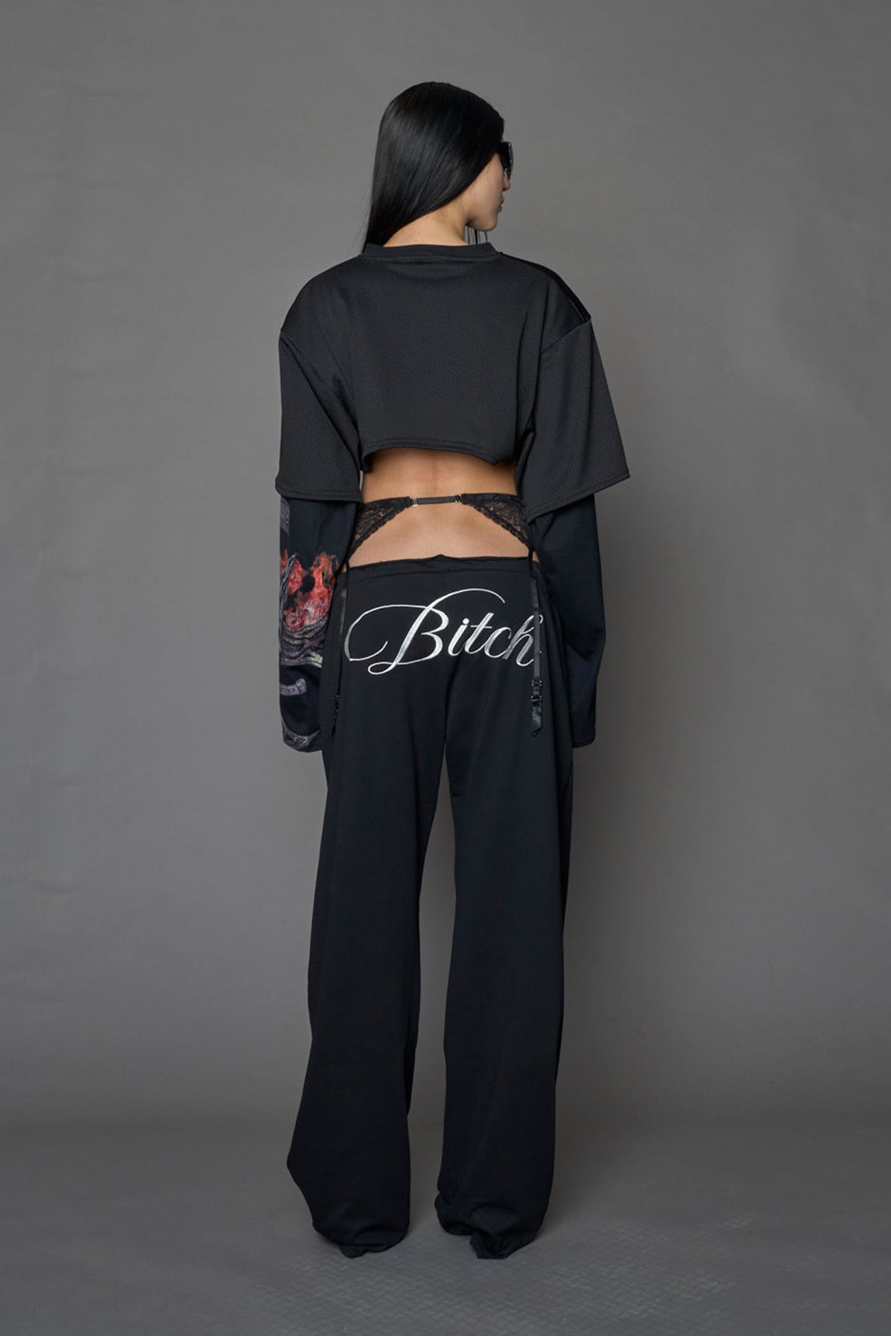 female model wearing a black cropped football inspired T-Shirt with a goth-inspired print