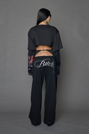 female model wearing a black cropped football inspired T-Shirt with a goth-inspired print