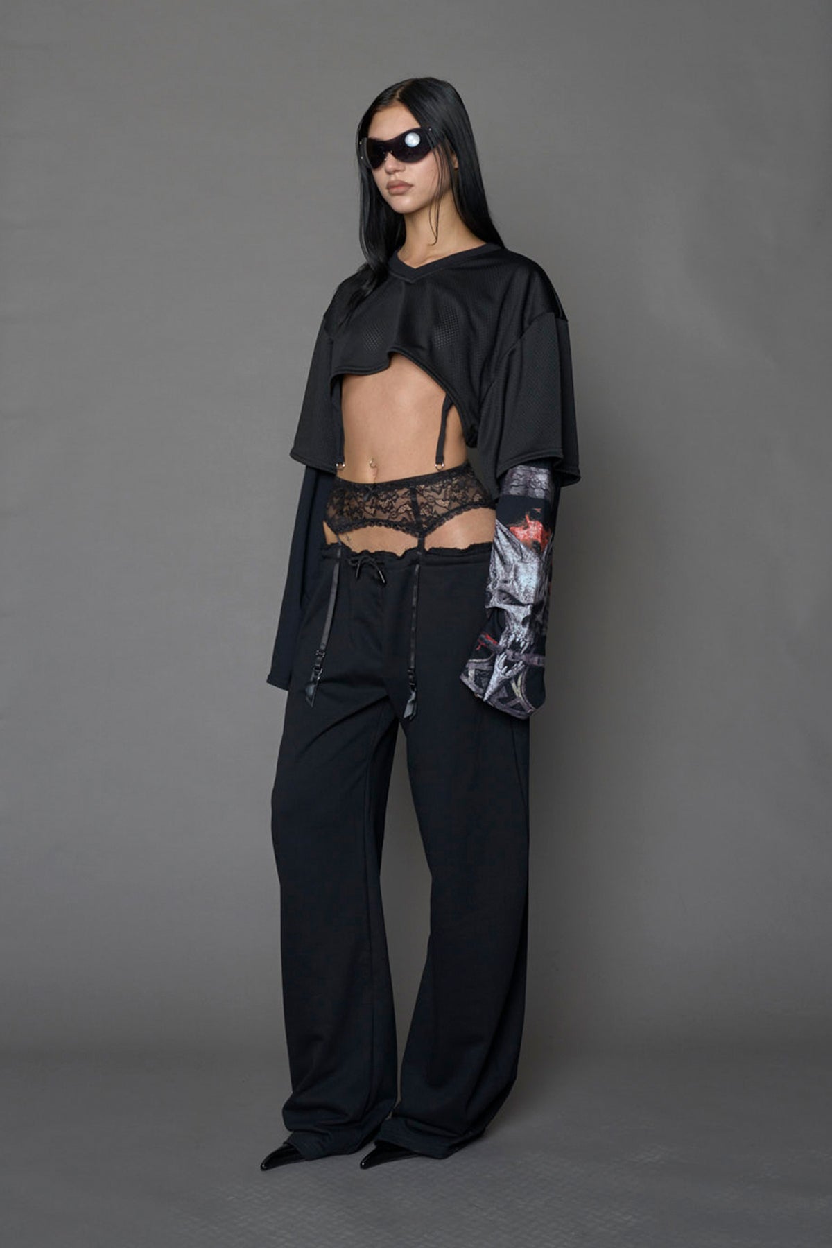 female model wearing a black cropped football inspired T-Shirt with a goth-inspired print