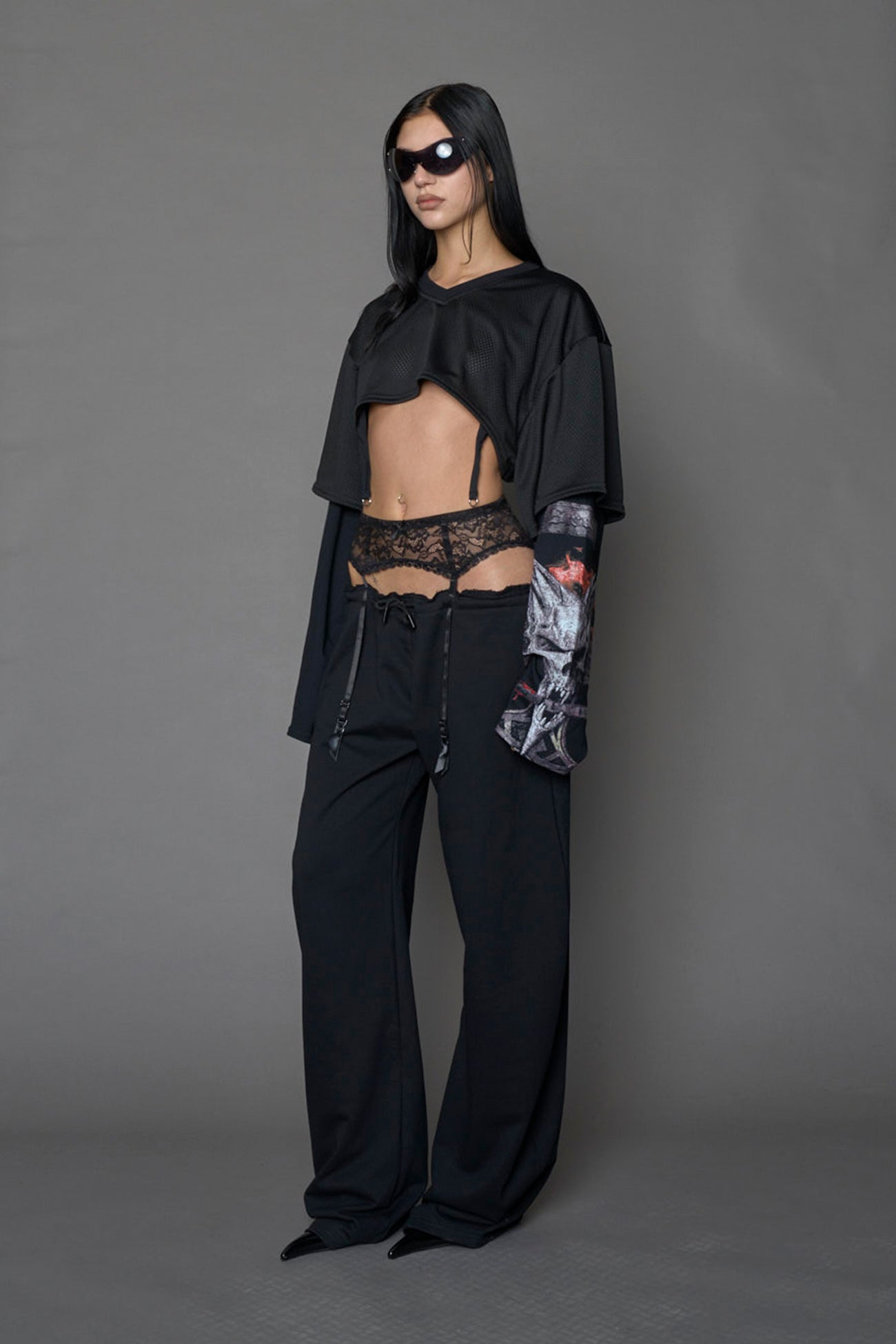 female model wearing a black cropped football inspired T-Shirt with a goth-inspired print