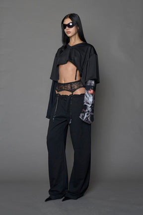 female model wearing a black cropped football inspired T-Shirt with a goth-inspired print