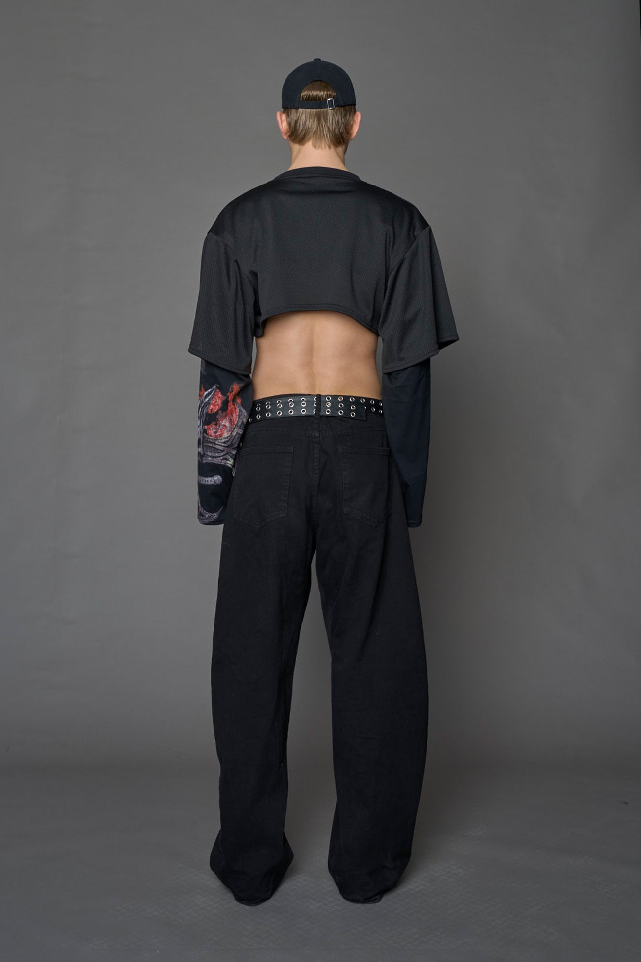 male model wearing a black cropped football inspired T-Shirt with a goth-inspired print