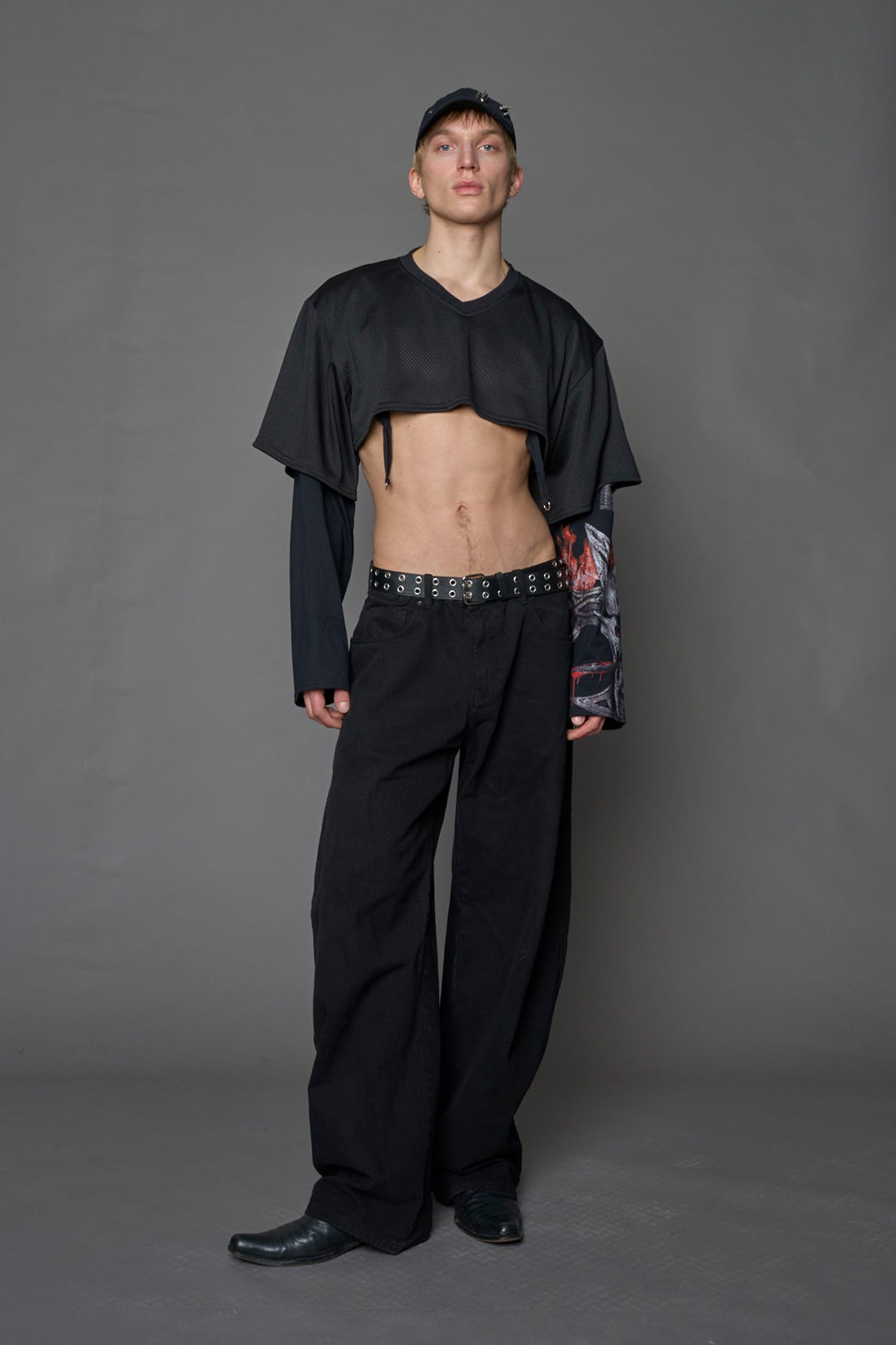 male model wearing a black cropped football inspired T-Shirt with a goth-inspired print