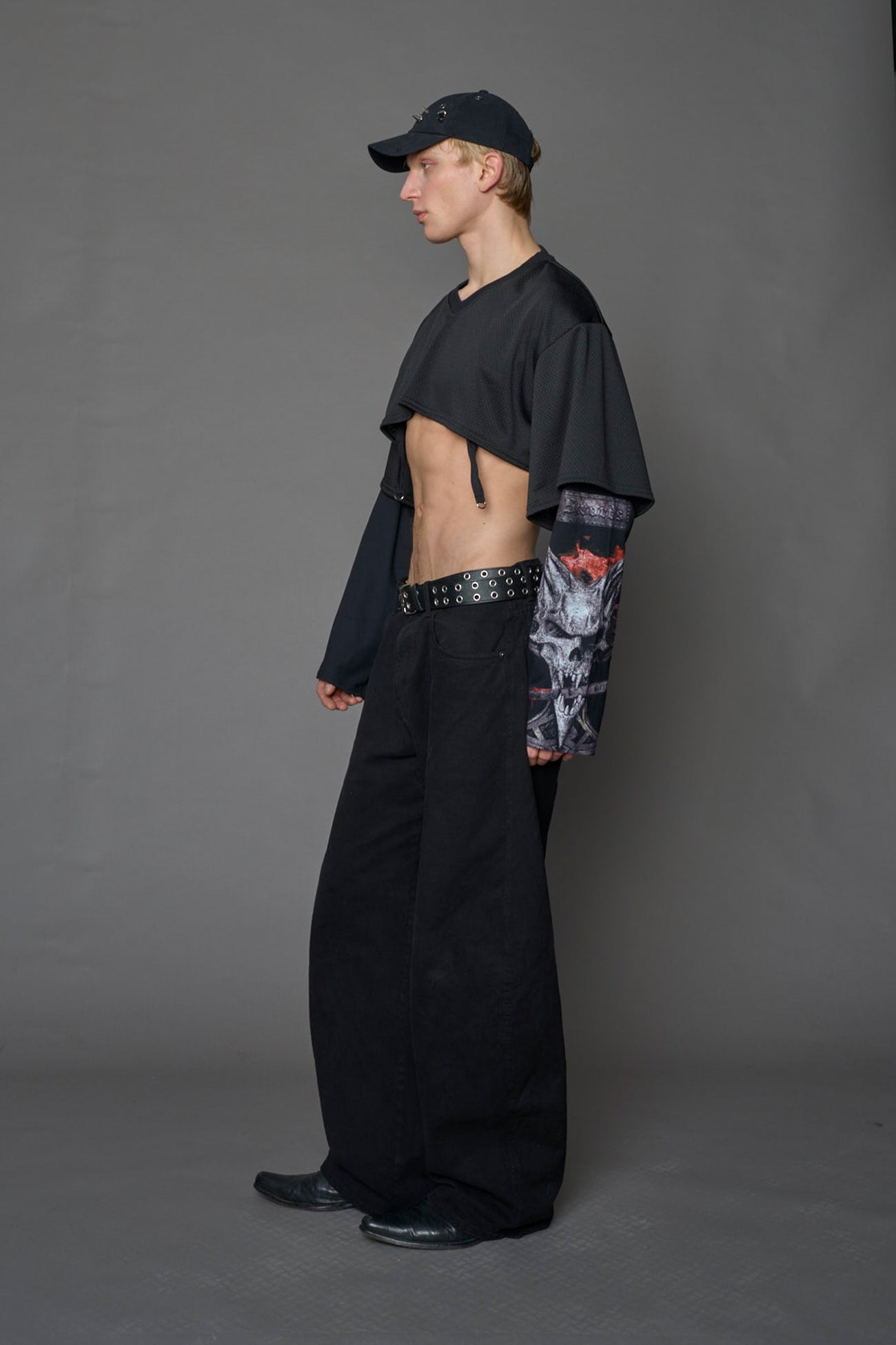 male model wearing a black cropped football inspired T-Shirt with a goth-inspired print