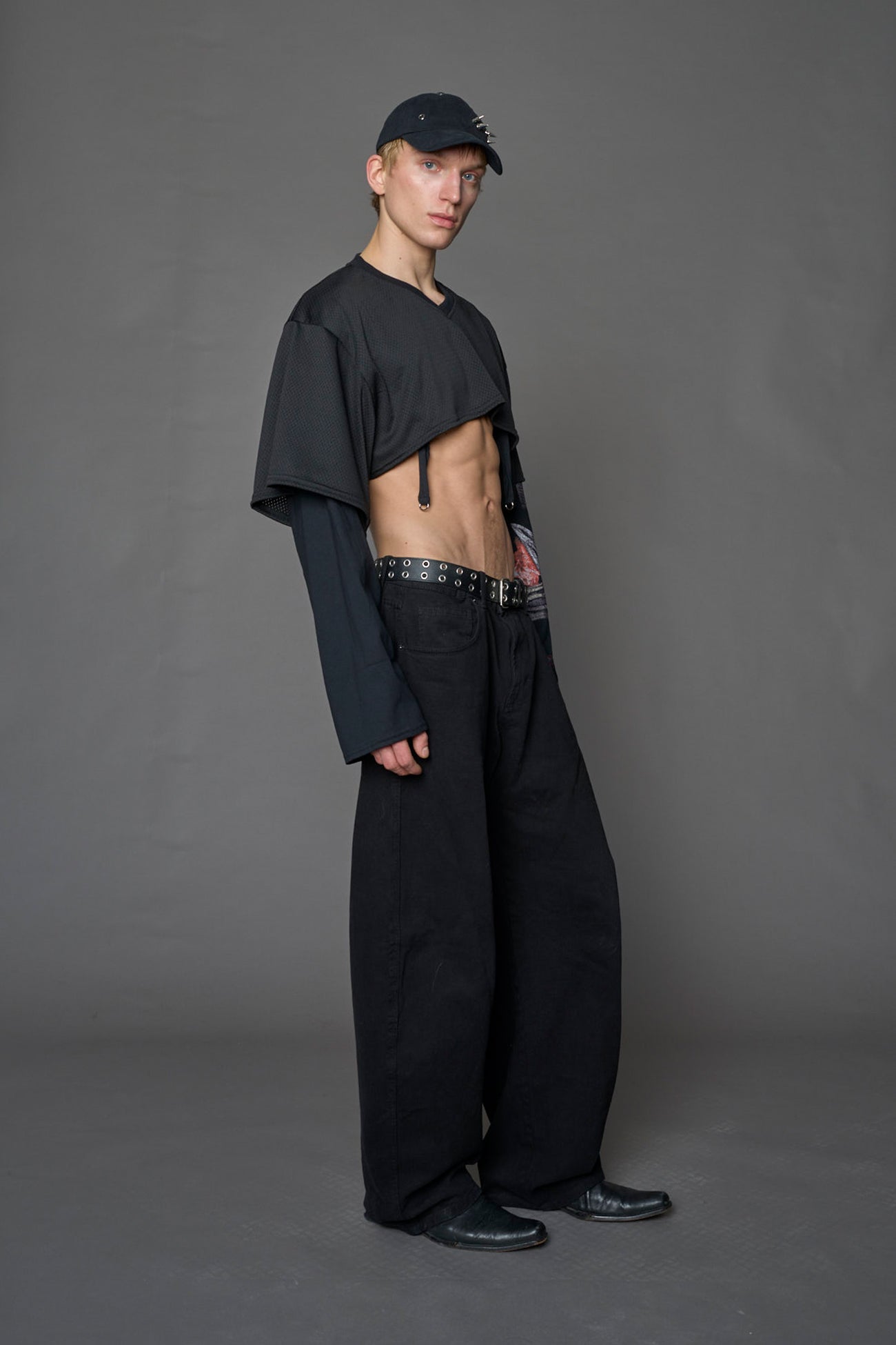 male model wearing a black cropped football inspired T-Shirt with a goth-inspired print