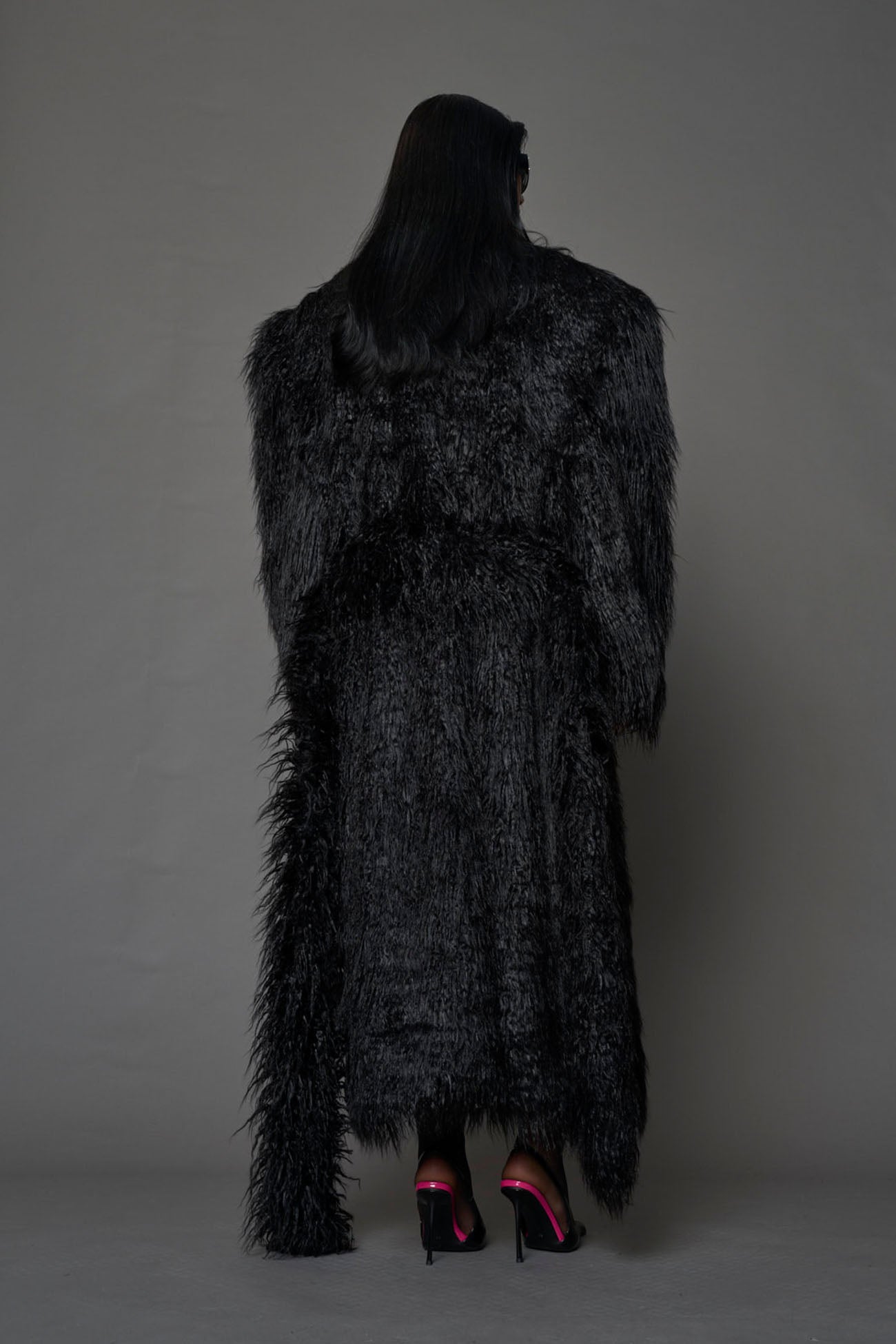 black faux fur coat with shoulder pads and  belt