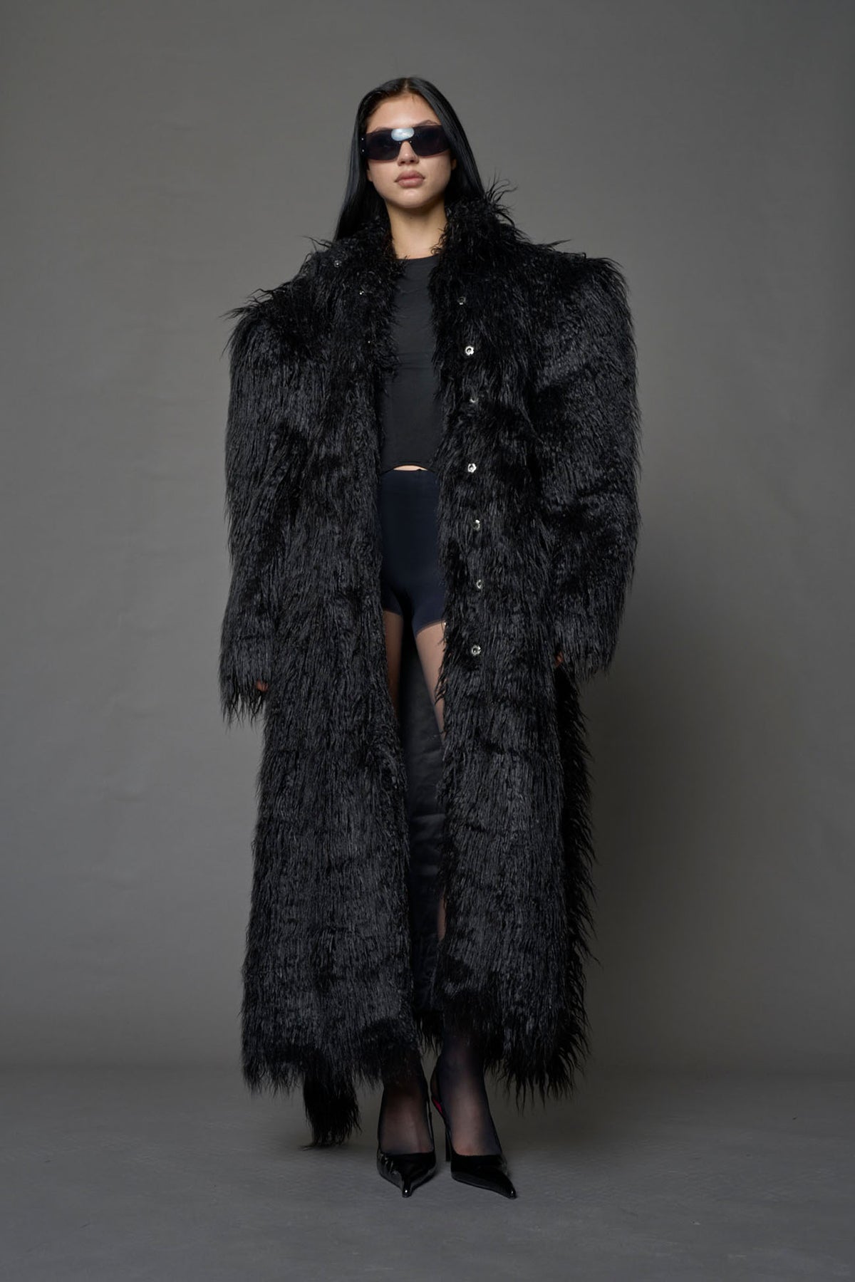 black faux fur coat with shoulder pads and  belt
