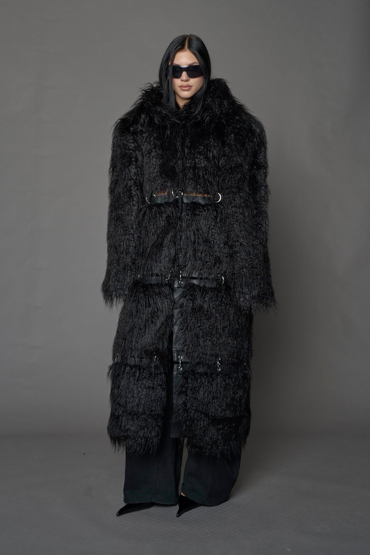 model wearing black faux fur coat with silver metal rings