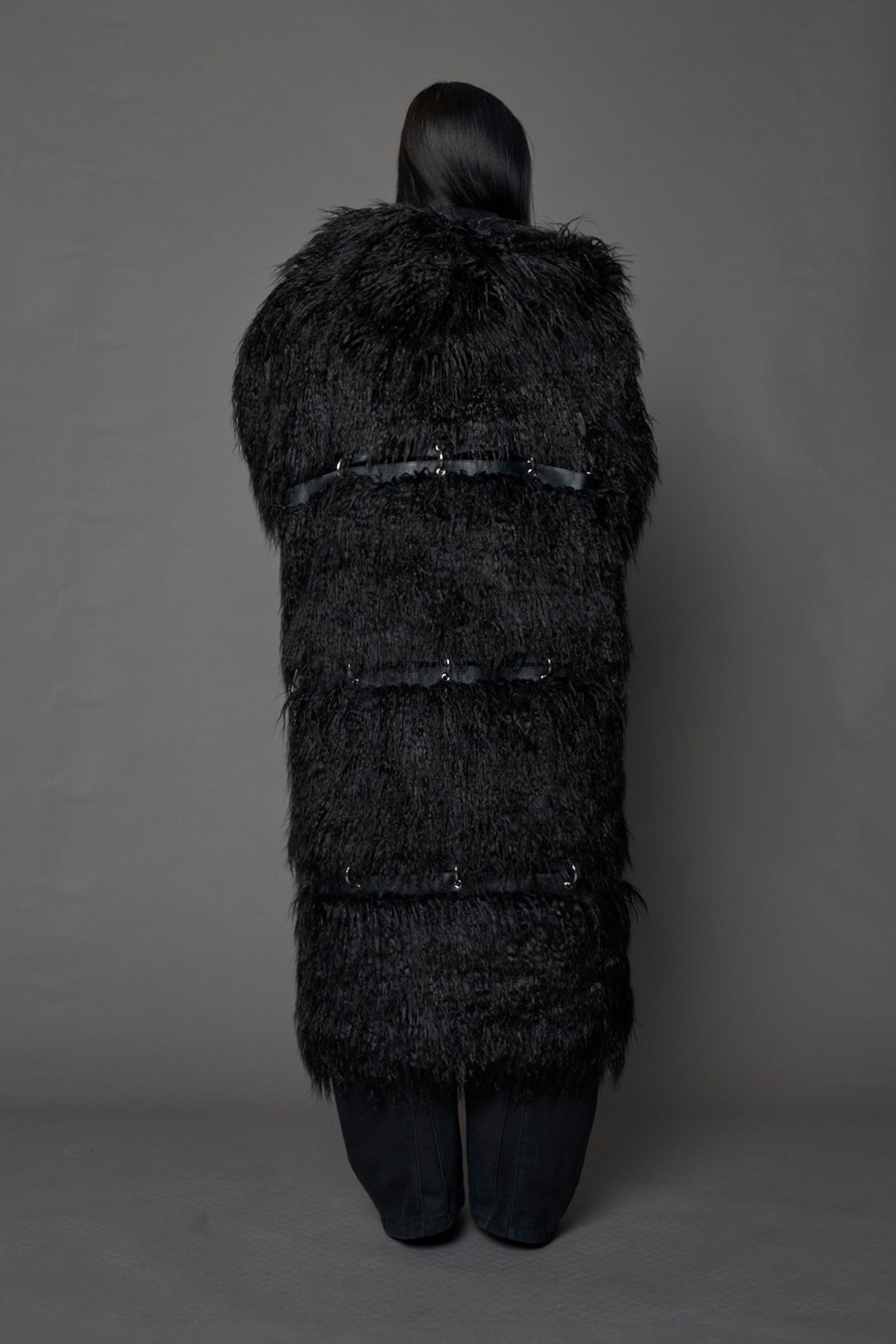 model wearing black faux fur coat with silver metal rings