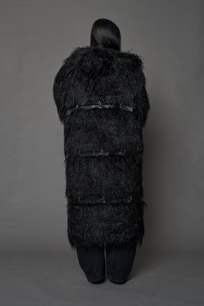 model wearing black faux fur coat with silver metal rings