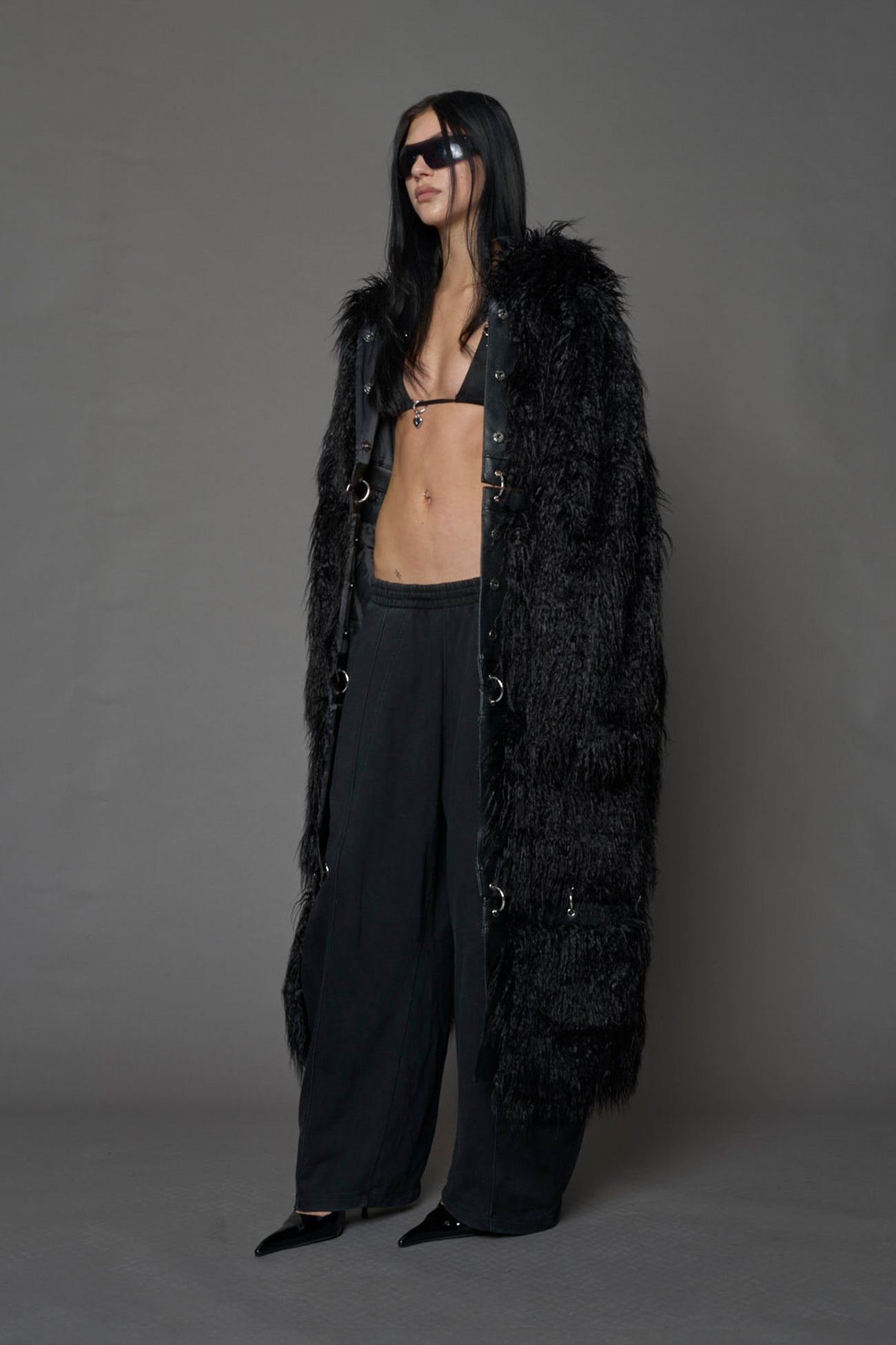 model wearing black faux fur coat with silver metal rings
