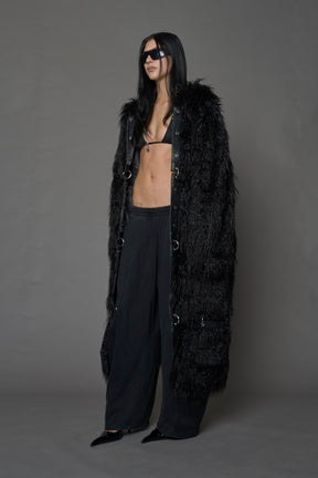 model wearing black faux fur coat with silver metal rings