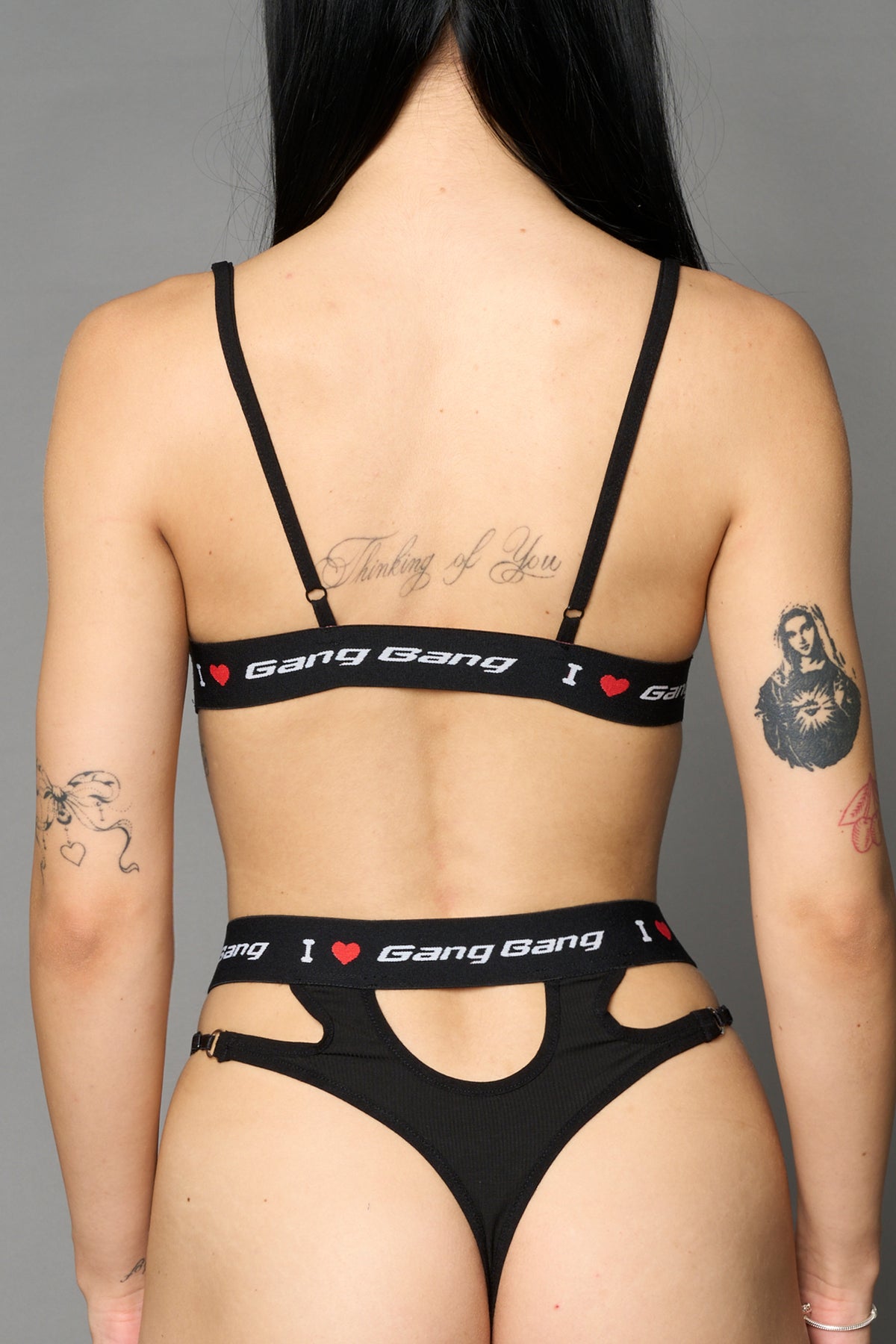 Black Namilia thong with strappy cut-out front, metal ring details and elastic waistband