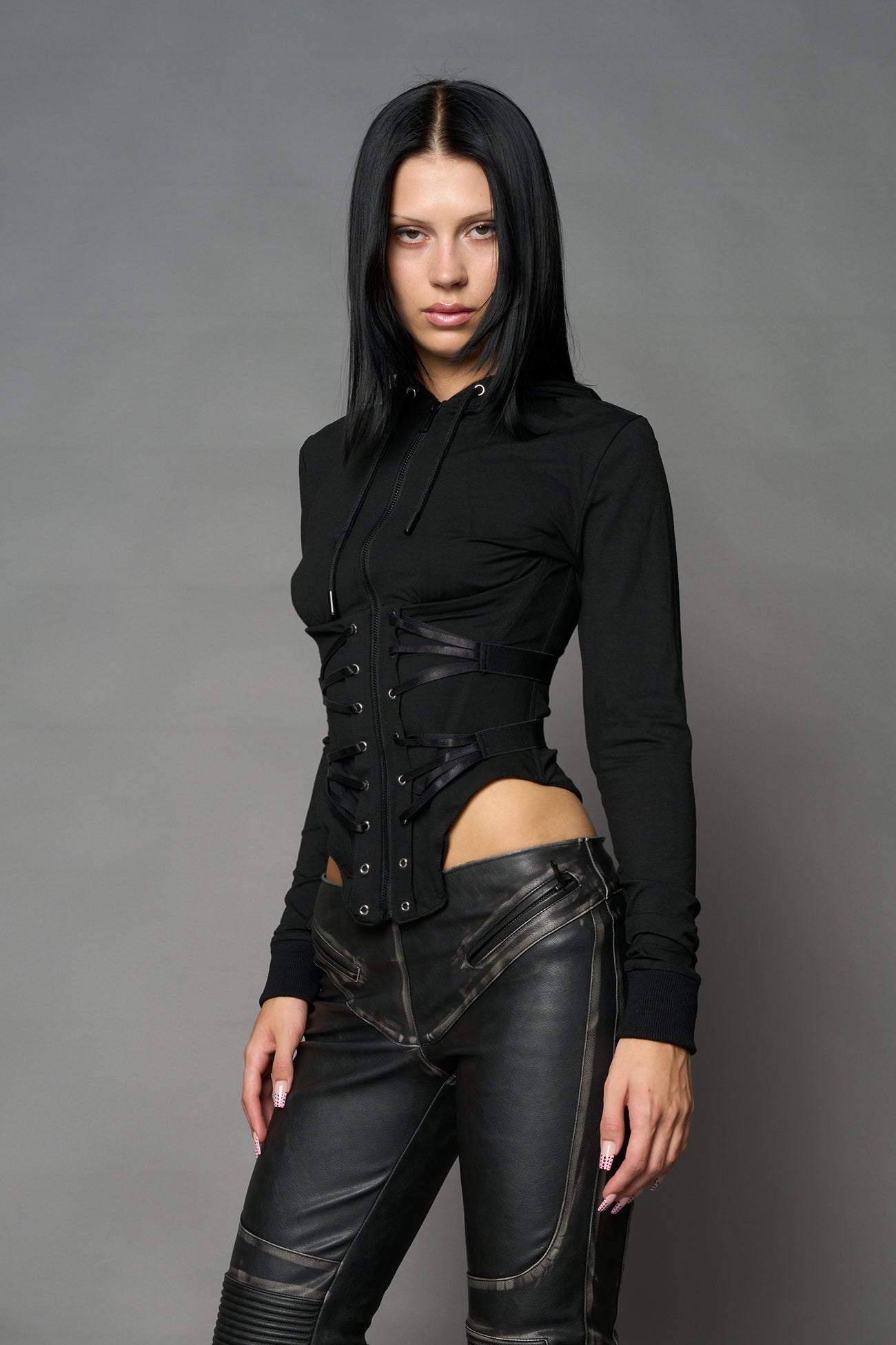 Black Namilia zip-up hoodie with built-in corset, lace-up front, cut-out sides and drawstring hood