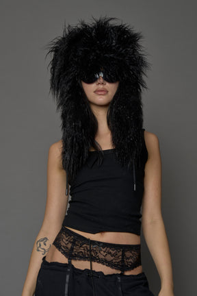 Model wearing oversized black and cream faux-fur hood hat with drawstrings