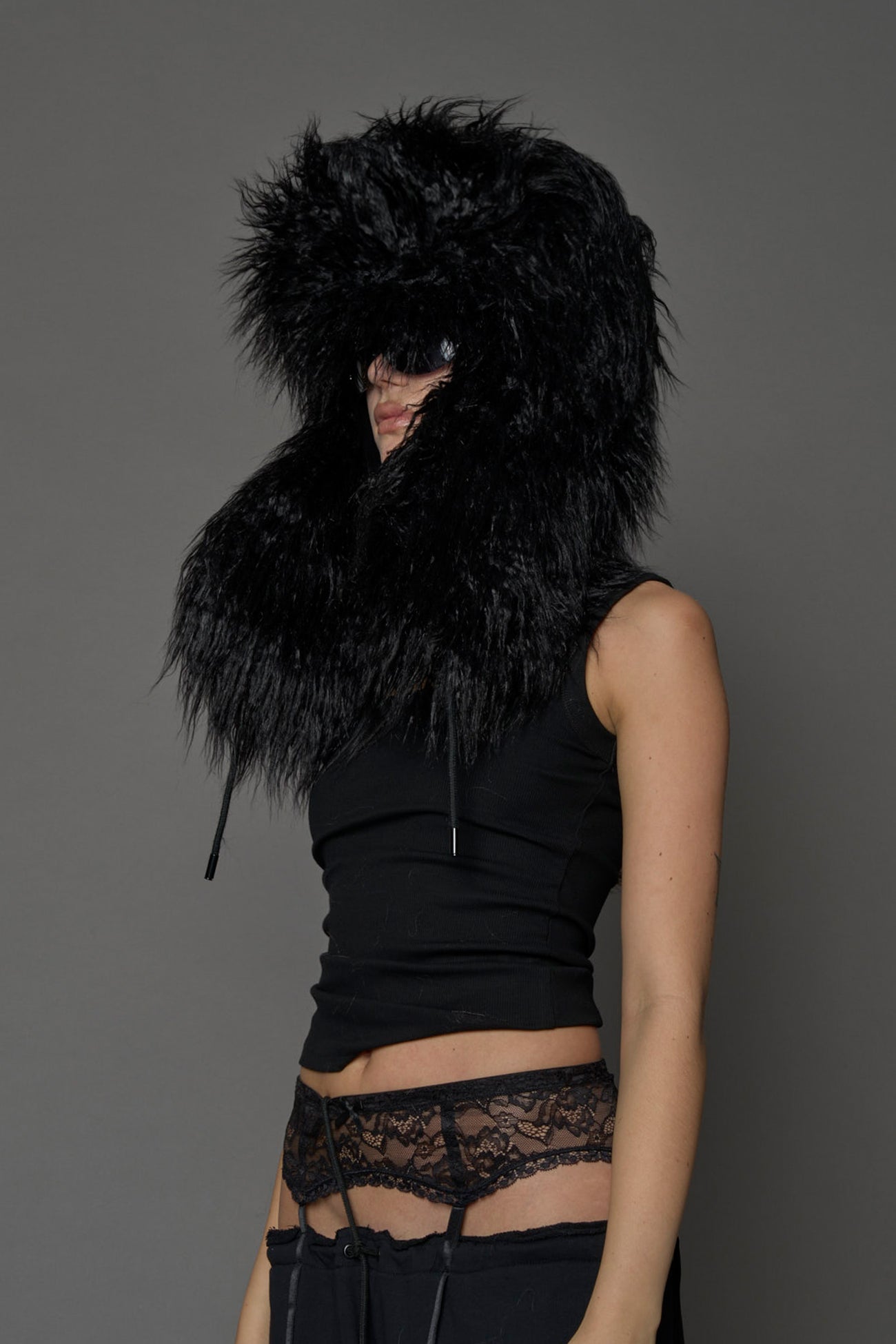 Model wearing oversized black and cream faux-fur hood hat with drawstrings