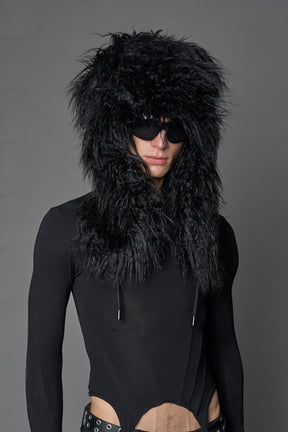 Model wearing oversized black and cream faux-fur hood hat with drawstrings