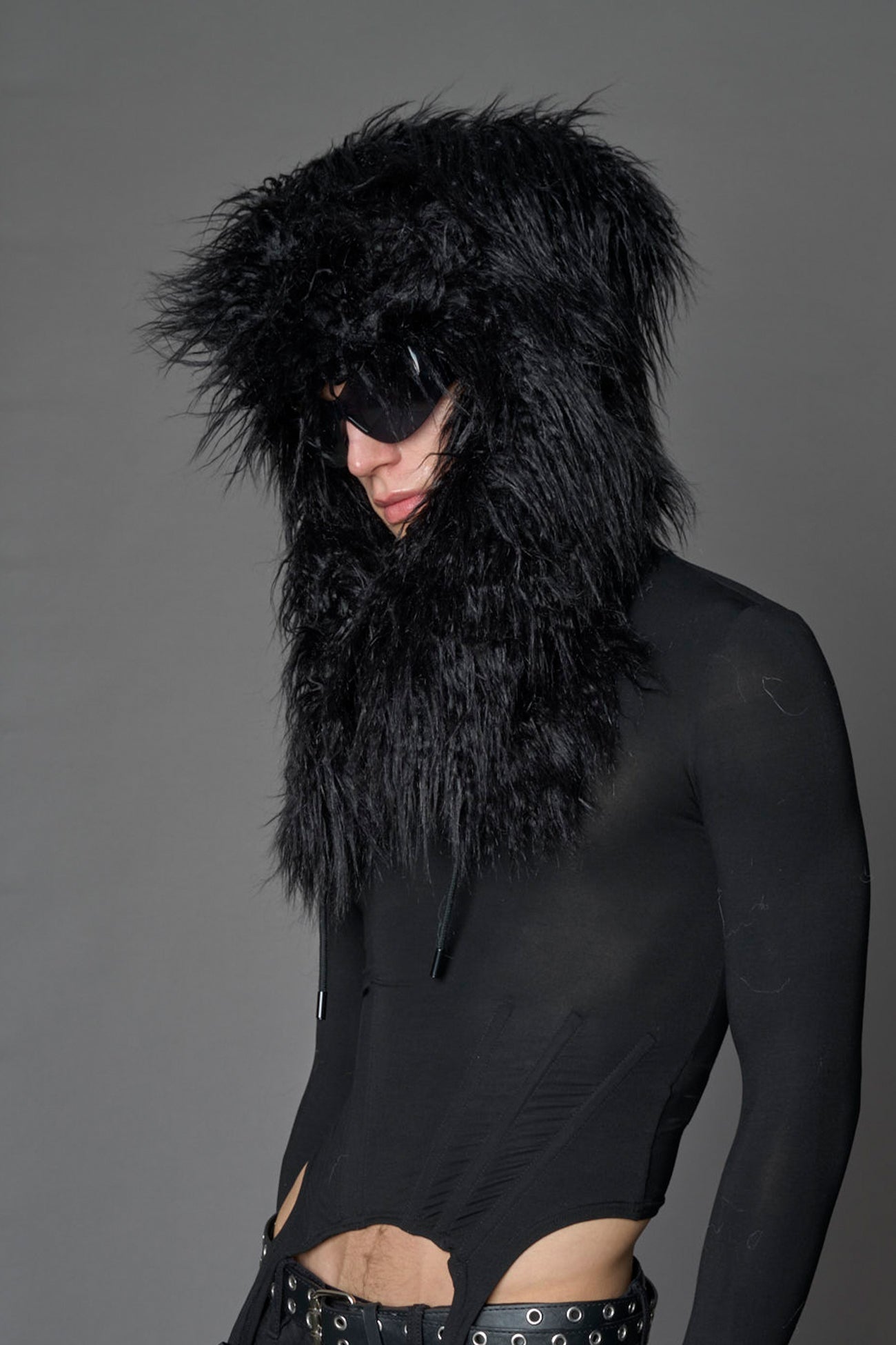 Model wearing oversized black and cream faux-fur hood hat with drawstrings